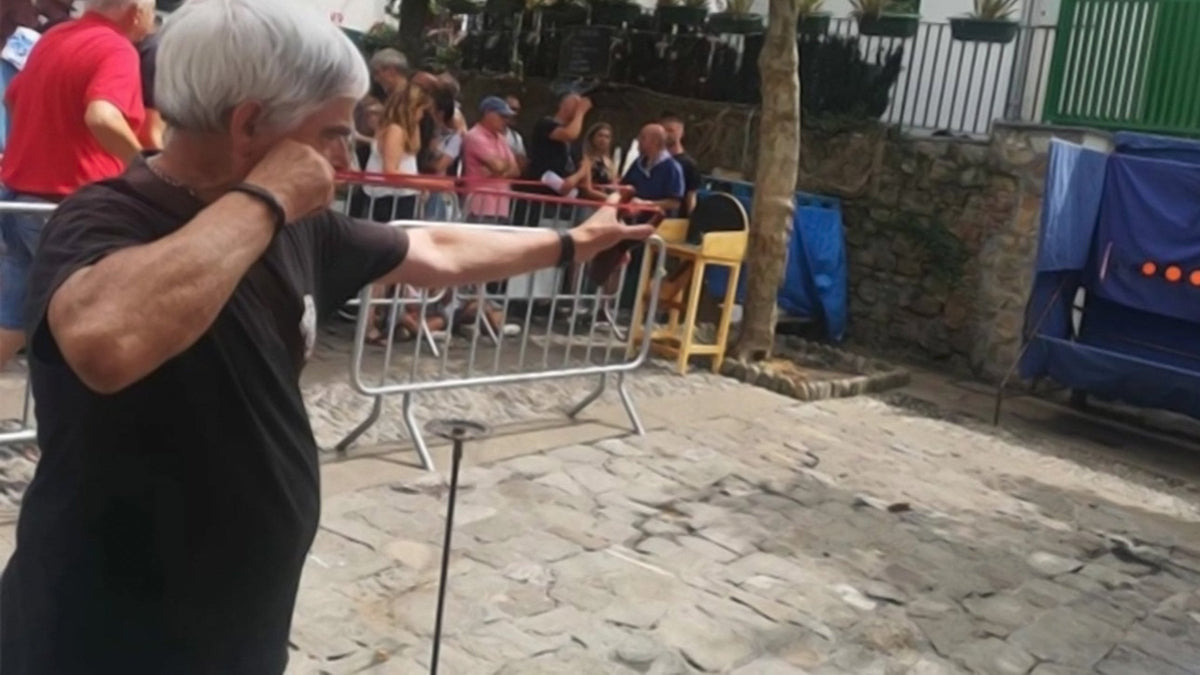 Tirador apuntando con un tirachinas a una diana en una competición al aire libre