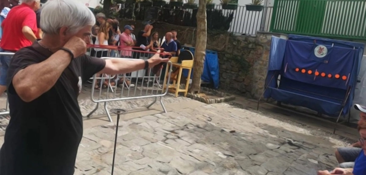 Tirador apuntando con un tirachinas a una diana en una competición al aire libre